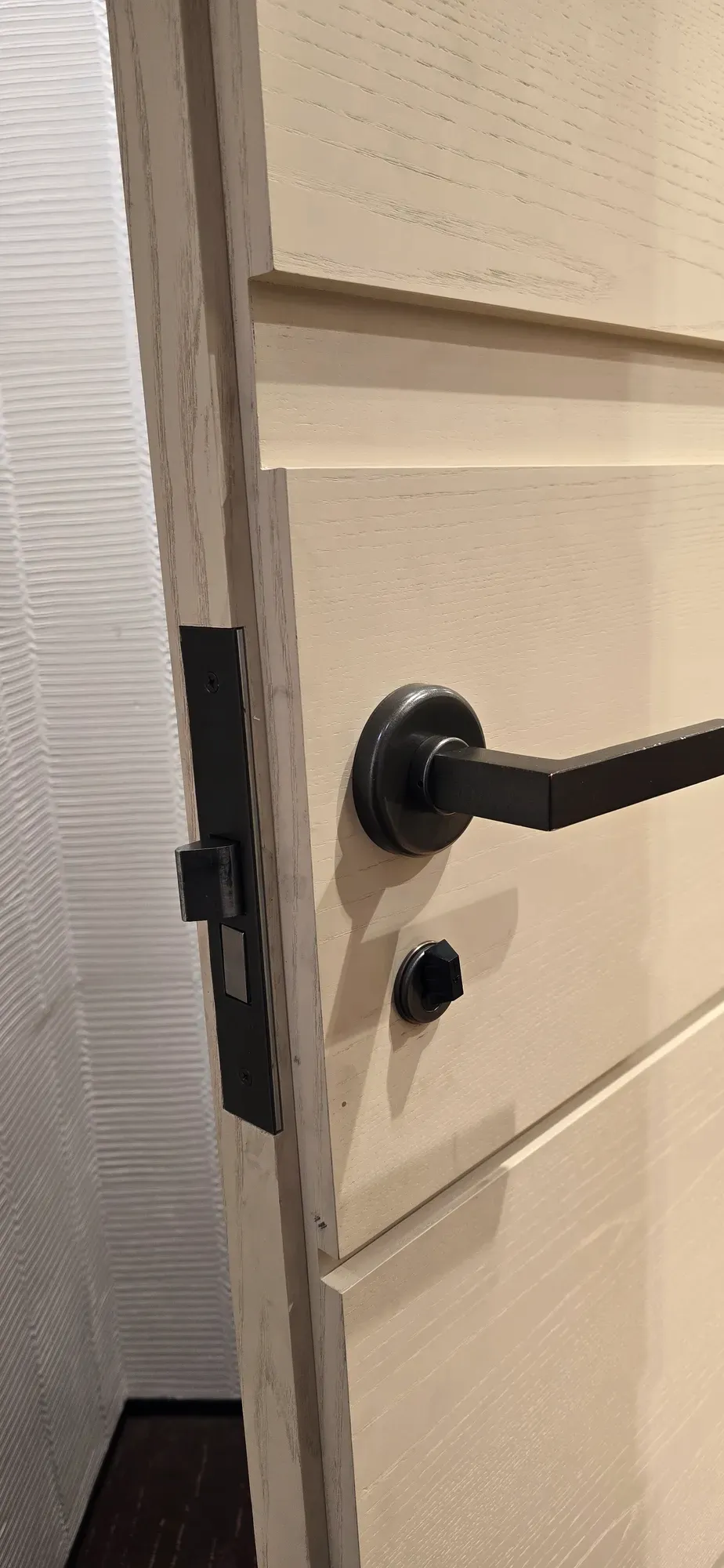 Dark bronze mortise lever and thumbturn on a light interior door