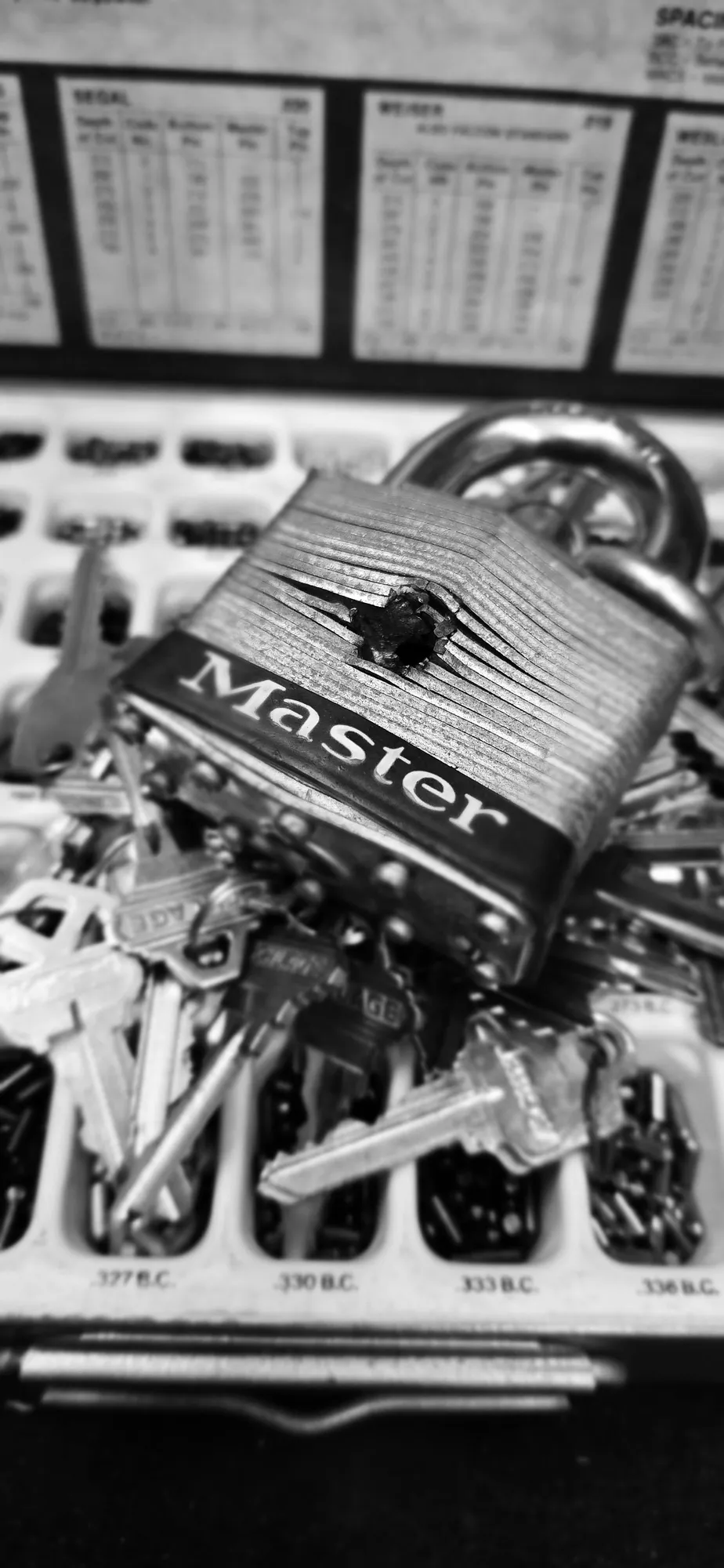 Drilled Master padlock on a locksmith key bench